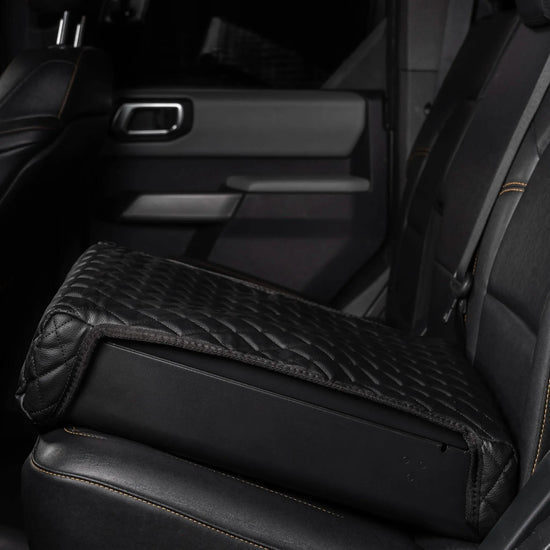Boosted Safe Elite hidden vehicle safe with black quilted leather cover installed on rear car seat.