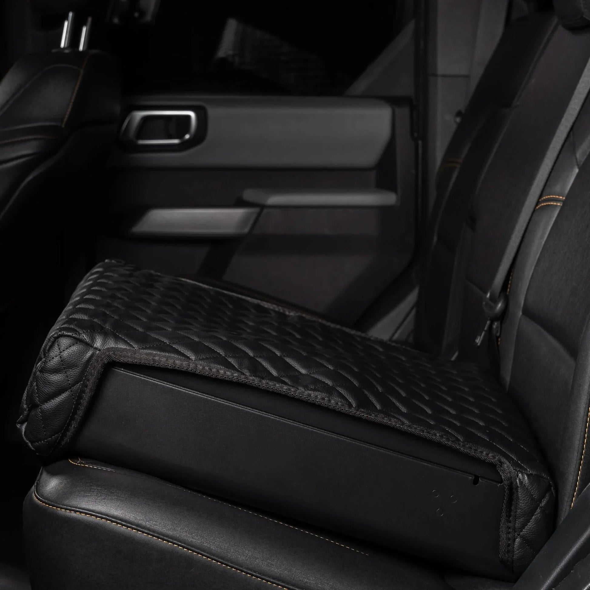 Boosted Safe Elite hidden vehicle safe with black quilted leather cover installed on rear car seat.