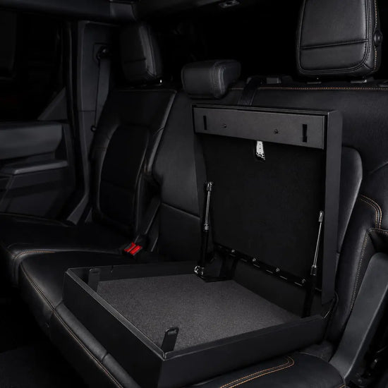 Open Boosted Safe installed beneath a truck rear seat, showing the spacious foam-lined storage compartment.