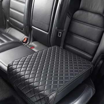 BoostedSafe disguised as a black quilted booster seat cover on a rear vehicle seat.