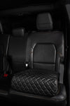 BoostedSafe Elite disguised as a black quilted booster seat cover in a rear SUV seat.
