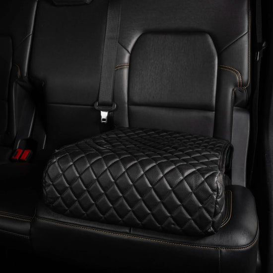 BoostedSafe Elite hidden car safe disguised as a black quilted booster seat in vehicle interior.