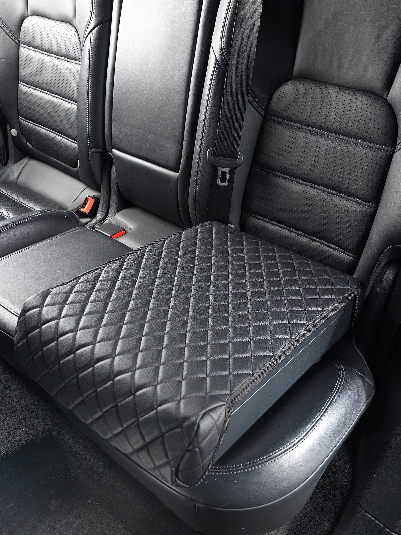 BoostedSafe Elite closed under quilted cover on a rear vehicle seat.
