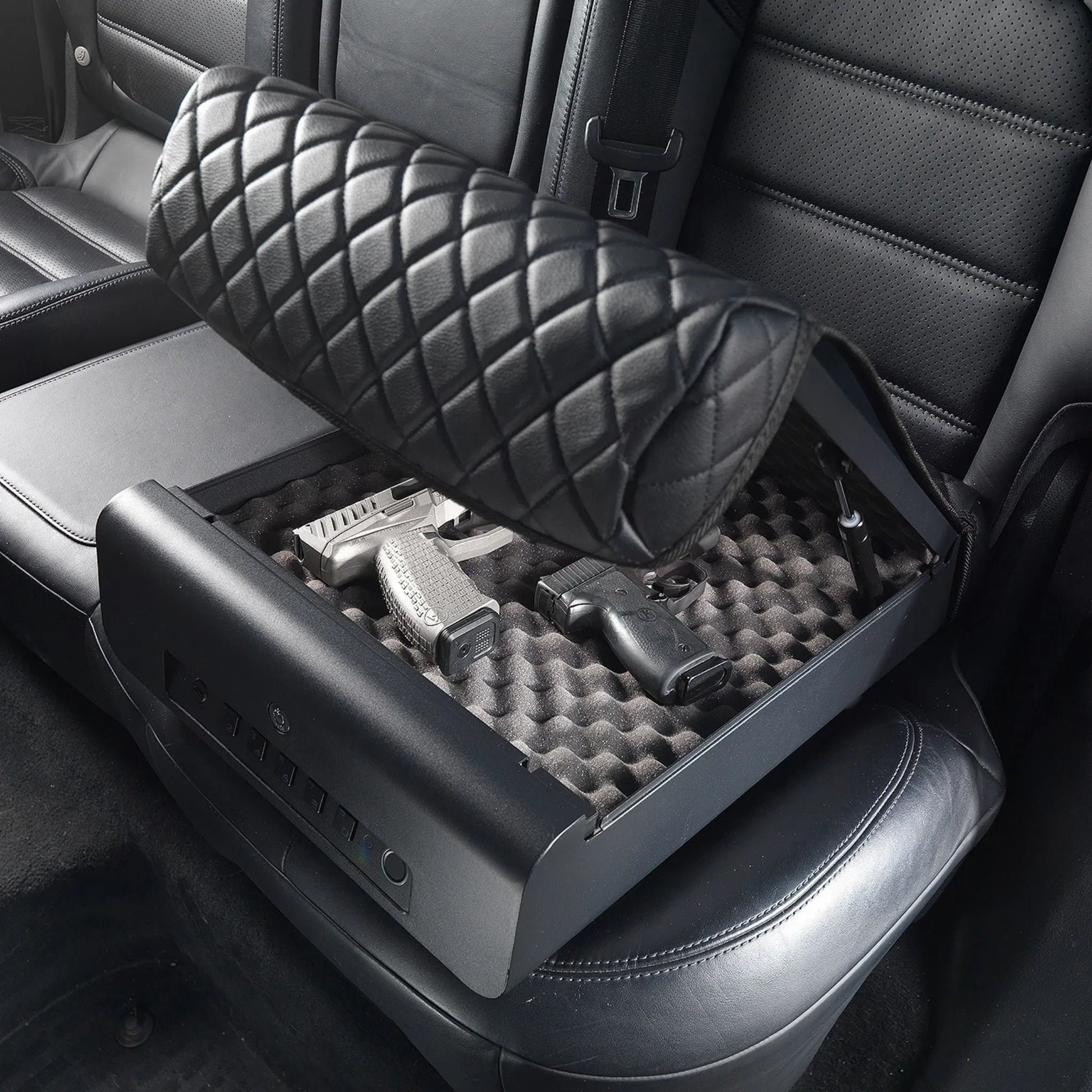 Open refurbished BoostedSafe Elite biometric vehicle safe storing two handguns inside a foam-lined rear seat compartment.