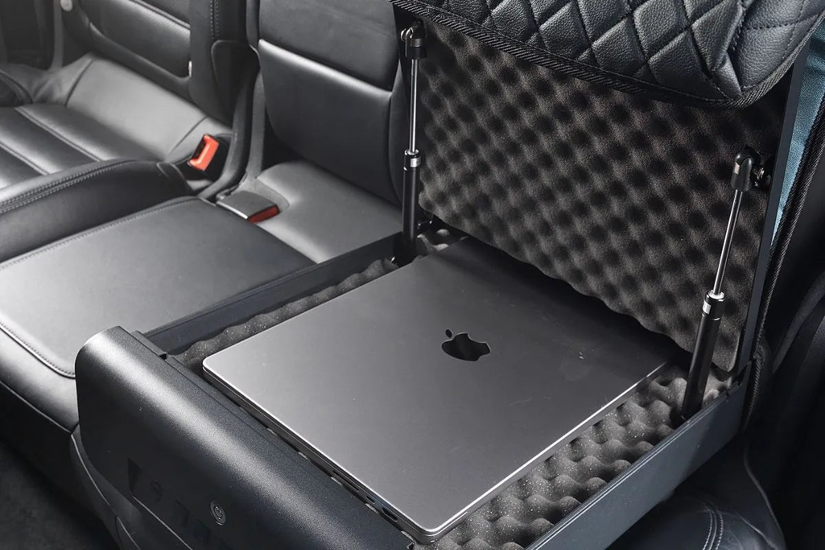 Boosted Safe Elite open on a car's back seat with a laptop resting on the foam lining