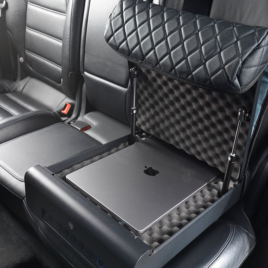 Open BoostedSafe Elite storing a laptop on foam padding in a rear vehicle seat.