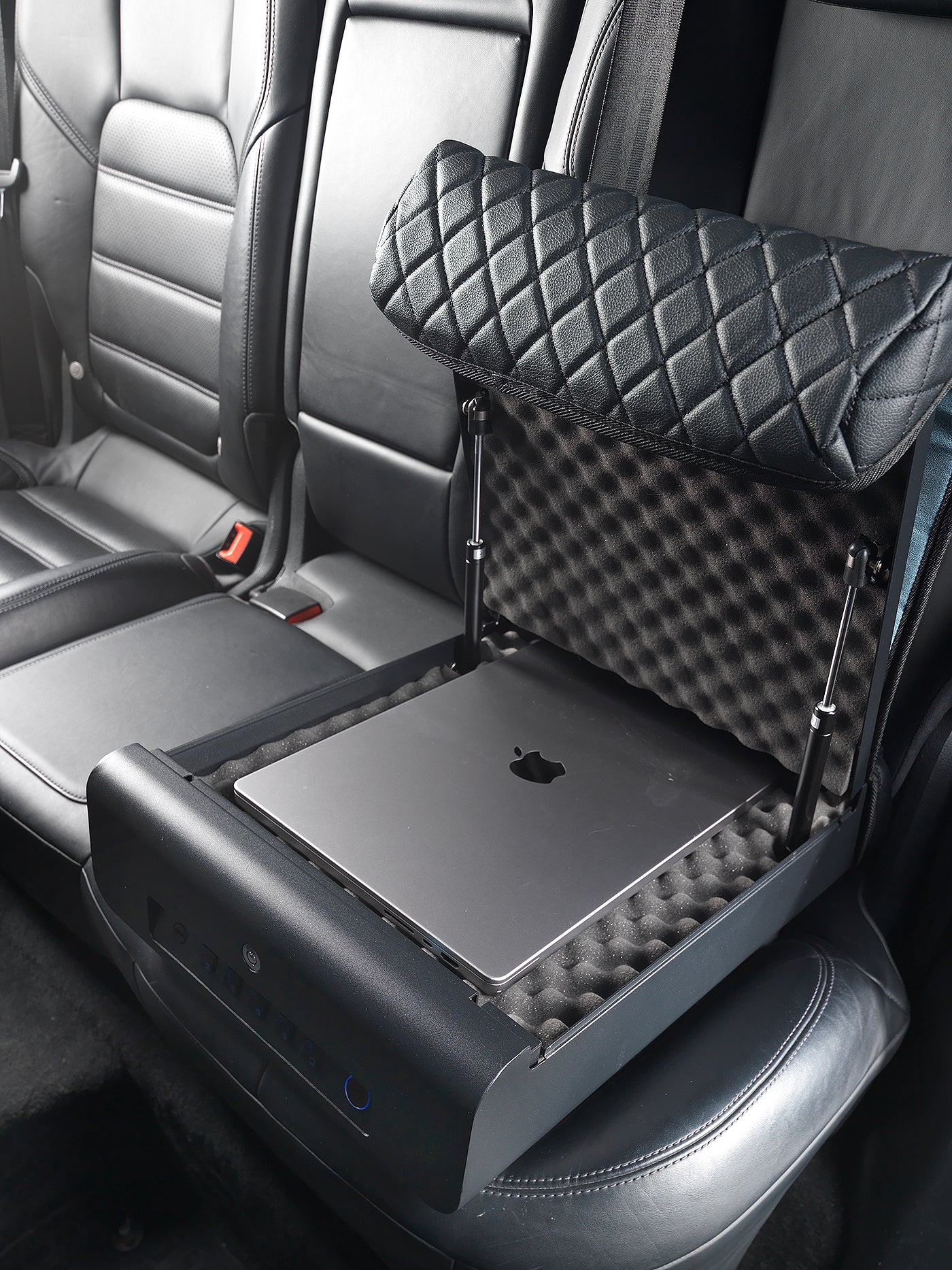 Open BoostedSafe Elite storing a laptop on foam padding in a rear vehicle seat.