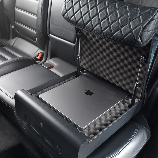 Open refurbished BoostedSafe Elite biometric vehicle safe storing a laptop inside the foam-lined rear seat compartment.