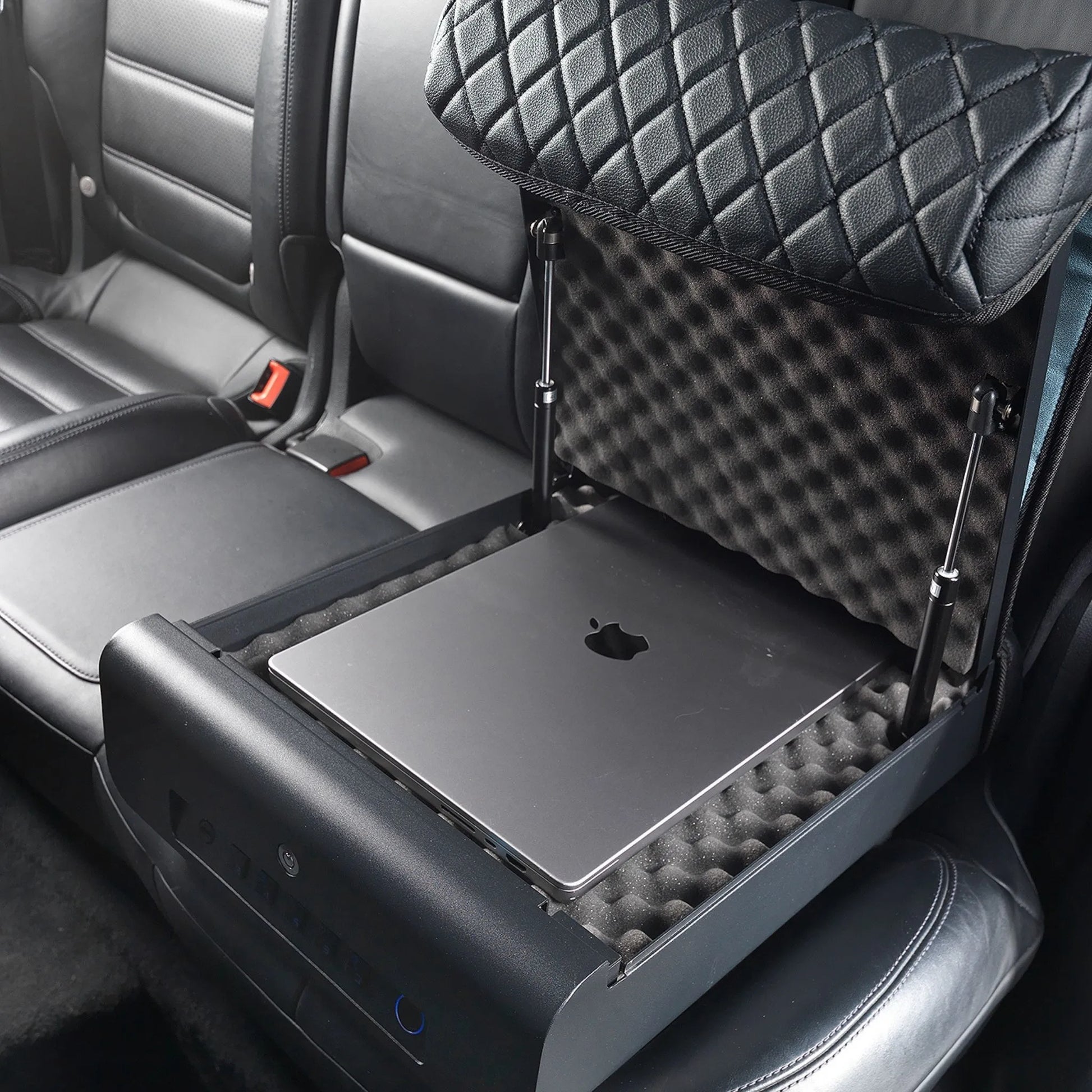 Open refurbished BoostedSafe Elite biometric vehicle safe storing a laptop inside the foam-lined rear seat compartment.