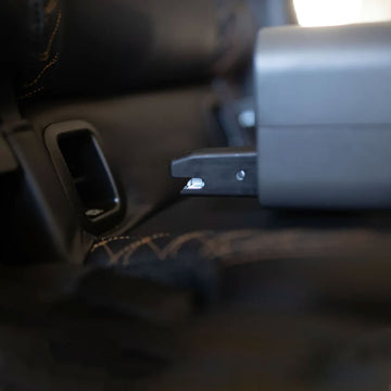 Close-up of BoostedSafe ISOFIX connector locked into a vehicle seat anchor.