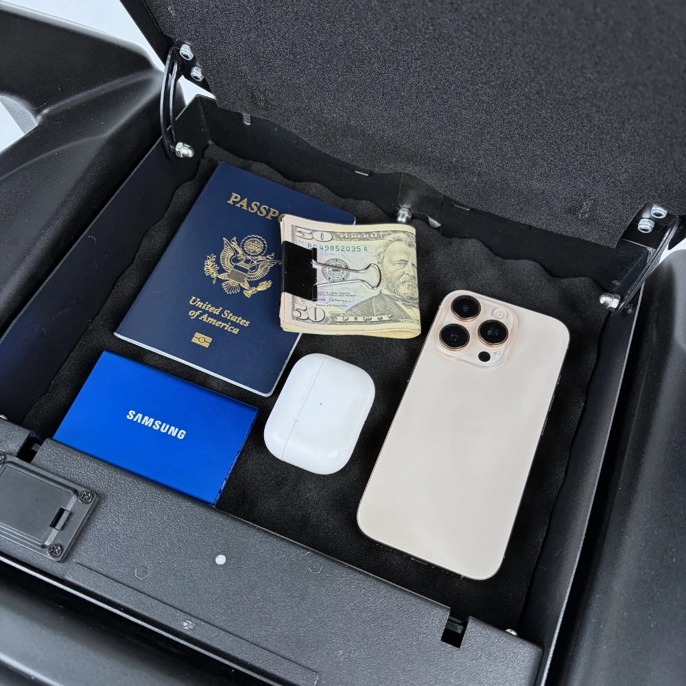 BoostedSafe Mini Elite hidden compartment holding a passport, cash, smartphone, earbuds, and small electronics