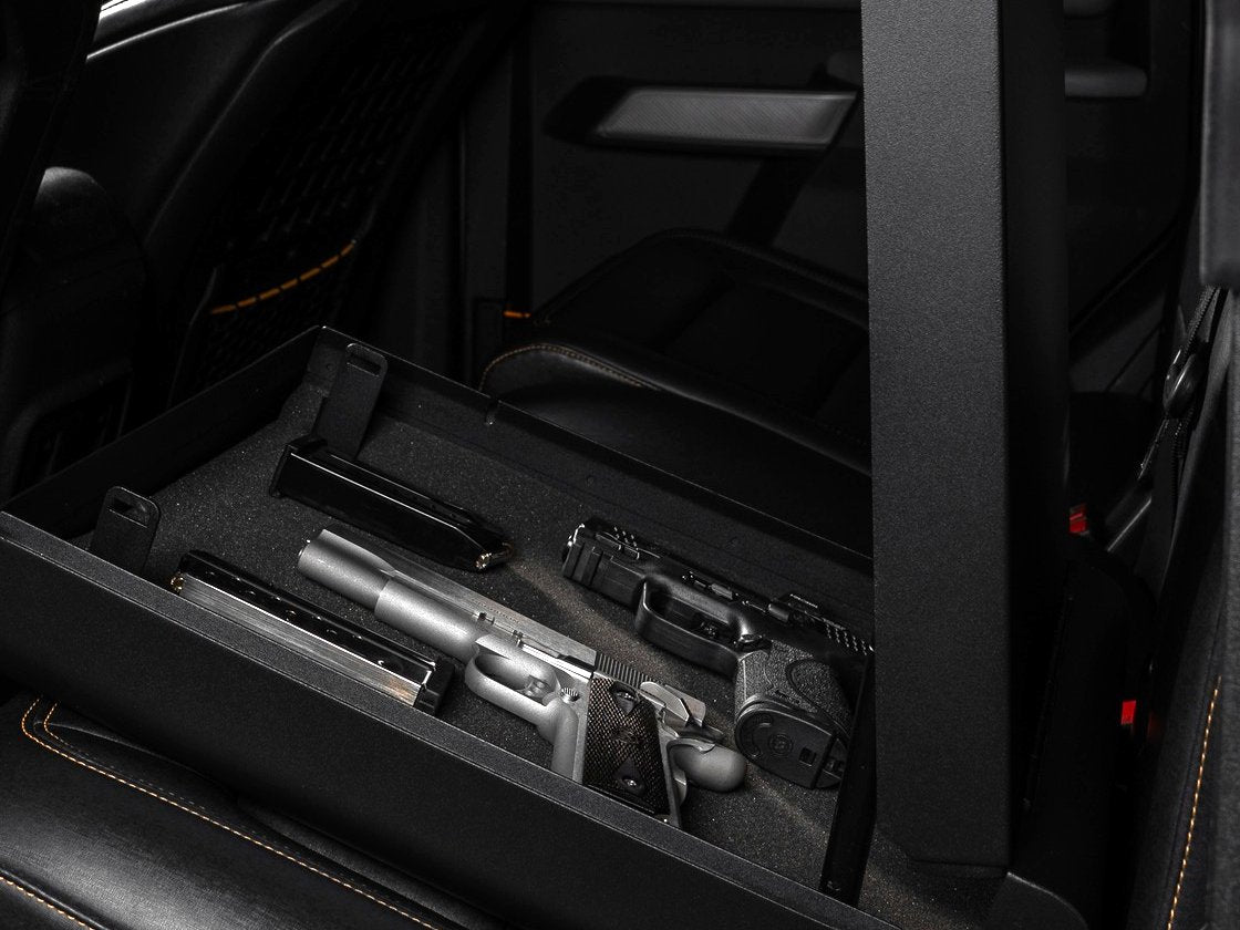 Golden Gate car gun safe open in the back seat of a pickup truck with two unloaded pistols, magazines out, in the foam