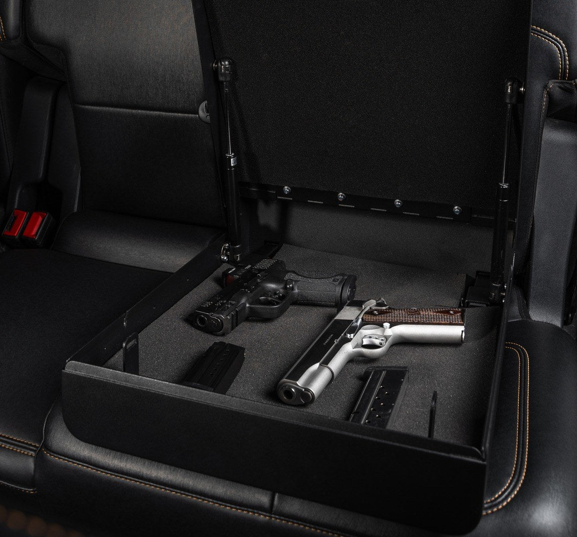 Golden Gate Basic car gun safe open on a back seat with an unloaded duty pistol, an unloaded 1911 and their magazines in foam