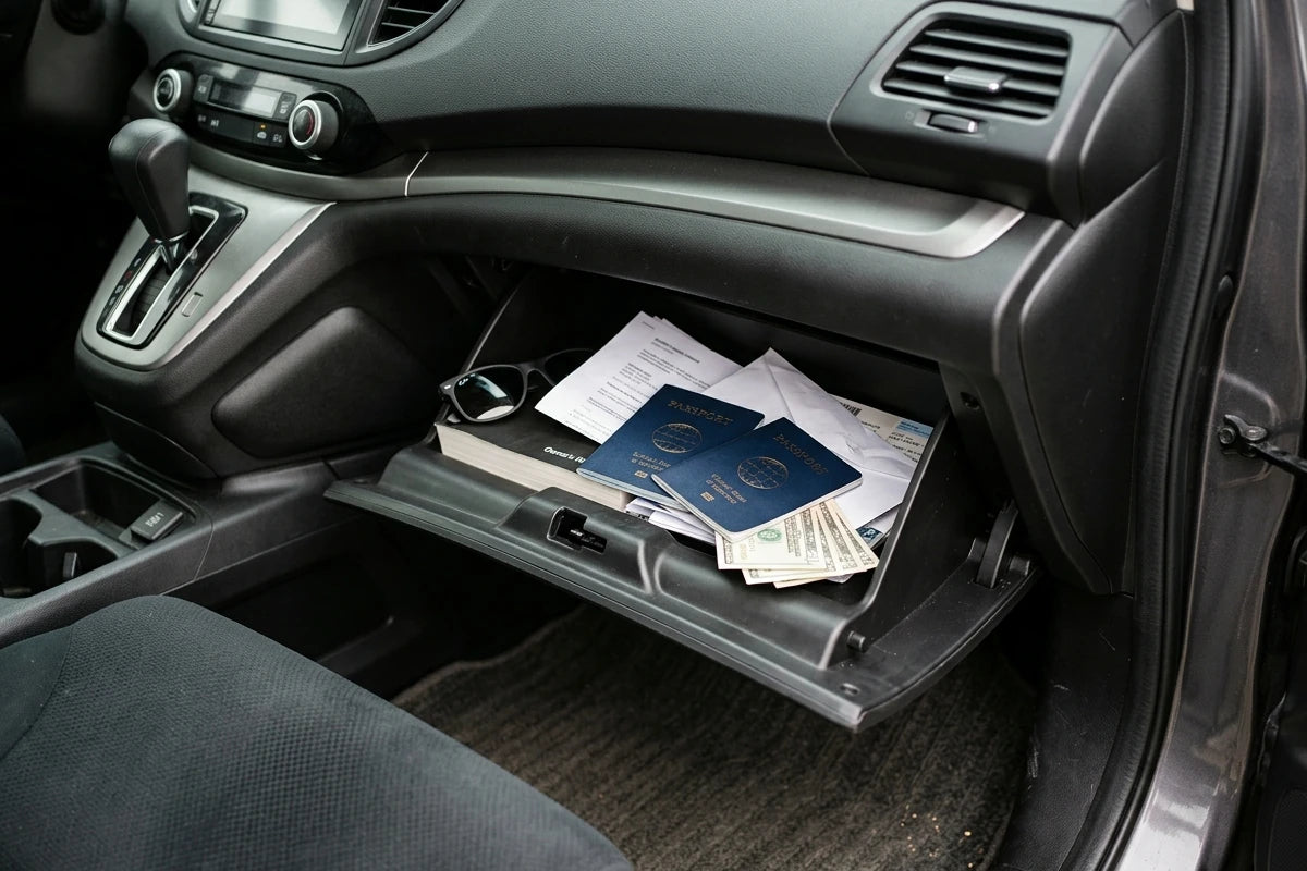 Passports, cash and papers in a car's open glove compartment