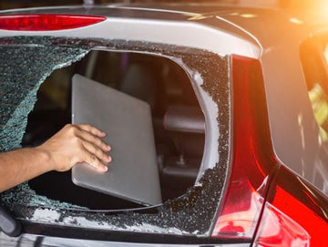 Broken vehicle window with a laptop being taken, showing theft risk without a car safe.